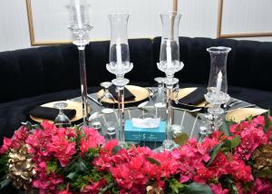 安曼ٍSandy Prime Hotel的一张桌子,上面放着酒杯和鲜花