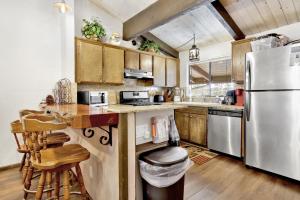 大熊湖2461-Smith Summit Chalet townhouse的厨房配有木制橱柜和不锈钢冰箱。