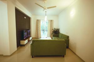 GoaAsta by Avim的客厅配有绿色沙发和电视