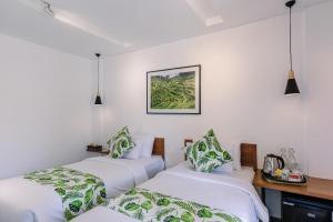 乌布Chandi Hotel Ubud的白色墙壁的客房内的三张床