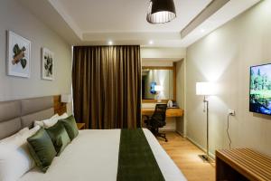 亚的斯亚贝巴君主酒店的配有一张床和一张书桌的酒店客房