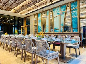 Ninh HòaTTC Van Phong Bay Resort的长长的用餐室配有长桌子和椅子
