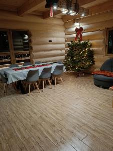 拉伊恰Domek u Sołtyska的一间设有桌椅的房间的圣诞树