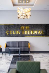 帕莫卡莱Çelik Thermal & Spa的大厅配有沙发和墙上的标志