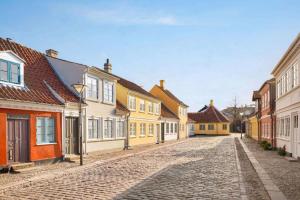 欧登塞Comwell H. C. Andersen Odense Dolce by Wyndham的城里一条鹅卵石街道,有五颜六色的房屋