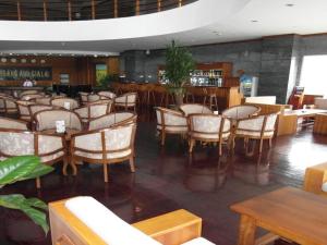 波来古市HAGL Hotel Gia Lai的一间带桌椅的餐厅和一间酒吧