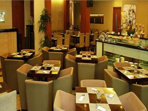 雅加达Grand Cemara Hotel的餐厅内带桌椅的用餐室