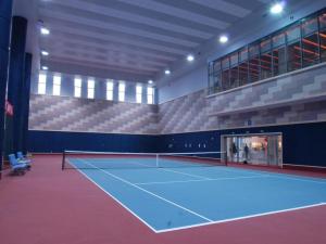 双流Sichuan Tennis International Hotel Main Building的一座网球场,位于一座带网球拍的建筑内