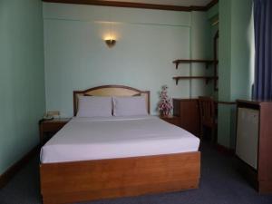 合艾Tanaphat Hatyai Hotel的一间卧室配有一张带白色床单的大床