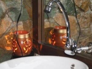 SorsogonVilla Isabel Hotel的浴室设有2把蜡烛,旁边是水槽
