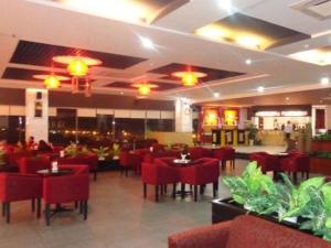 河静BMC Ha Tinh hotel的餐厅内带红色椅子和桌子的用餐室