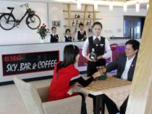 河静BMC Ha Tinh hotel的一群人坐在商店的桌子旁