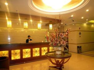 XuedianGreenTree Inn Jiangsu Wuxi Meiyuan Kaiyuan Temple Subway Master Station Express Hotel的站在酒店大堂柜台的男人