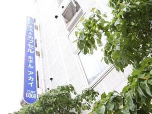 东京Hotel Akai的带有窗户和蓝色标志的建筑