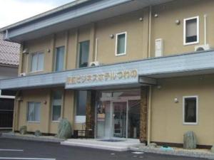 津和野町Business Hotel Tsuwano的一座酒店大楼,前面有标志