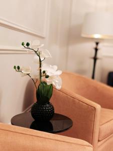 爱丁堡弗雷德里克大楼酒店的一张桌子上白色花的黑色花瓶
