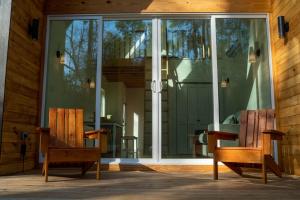 蒙哥马利Stay in Babia - Luxury Cabins - Sam Houston National Forest的两把木椅坐在玻璃门前
