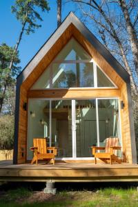 蒙哥马利Stay in Babia - Luxury Cabins - Sam Houston National Forest的一个小房子,设有大窗户和两把椅子