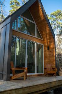 蒙哥马利Stay in Babia - Luxury Cabins - Sam Houston National Forest的小屋设有木甲板上的大窗户