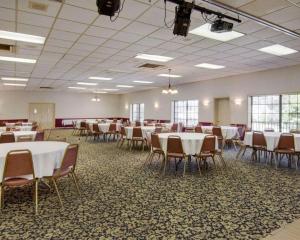 埃尔多拉多Econo Lodge Conference Center的宴会厅配有白色的桌椅