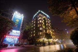 Ða HộiGia Bao Hotel Bac Ninh的一座高大的建筑,晚上有灯