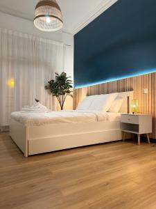 尼斯Sunshine Getaway - Stylish Studio in the Heart of Nice的卧室配有一张白色大床和蓝色的墙壁