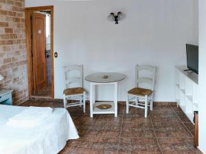 奇克拉纳－德拉弗龙特拉La Luciérnaga的卧室配有一张床和一张桌子及椅子