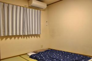 大阪Niji Homestay的小房间设有床和窗户