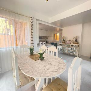 卡加盐德奥罗4BEDROOMS Elegant House For Family & Groups Staycation In Cagayan de Oro City的一间设有白色桌子和白色椅子的用餐室