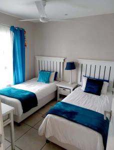 马盖特Indigo Bay 29的蓝色和白色的客房内的两张床