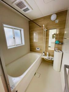 南鱼沼市Urasa Cottage @ Snow Countryside的一间带大浴缸和窗户的浴室