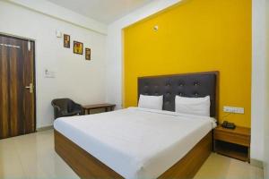 印多尔Hotel Shubhshree的一间卧室设有一张黄色墙壁的大床
