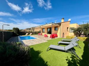 埃斯塔蒂特Villas Medes Mar - Plus Costa Brava的一个带椅子的庭院、一个游泳池和一个房子