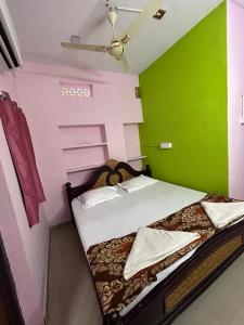 SrīsailamHotel R residence的小房间设有一张带绿色墙壁的床