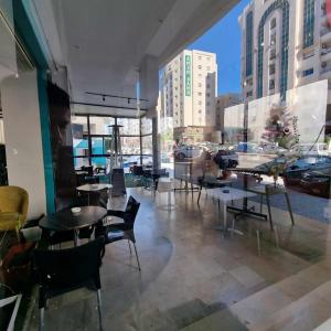 艾尔亚奈City View, Ennasr Spacious s2 Apartment的一间设有桌椅的餐厅,享有城市美景