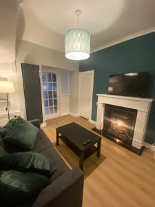 斯莱戈Newly Furnished 5 Bedroom Gem in Sligo的带沙发和壁炉的客厅
