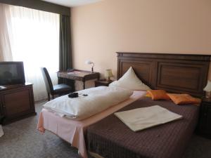 萨勒河畔哈雷AM RATSHOF的酒店客房设有一张大床和一张书桌。