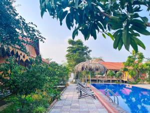 宁平Trang An Quynh Trang Happy Homestay & Garden的拥有长椅和树木的度假村的游泳池
