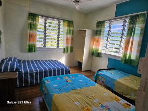 阿洛菲Heleni Jessop's Fatahega的一间卧室设有两张床和两个窗户。
