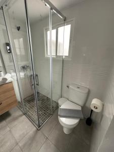 塔里法Apartamento Entre dos mares的白色的浴室设有卫生间和淋浴。