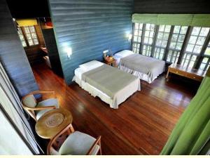 山都望珀麦雨林度假酒店的一间卧室配有两张床和一张桌子及椅子
