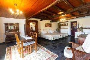 洛萨金塔尔德阿莱姆杜里贝罗-特里士姆乡村酒店的一间卧室配有两张床和一张桌子及椅子