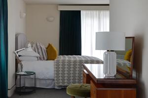 格拉斯米尔切斯特纳特别墅旅馆的一间卧室配有一张带镜子和桌子的床