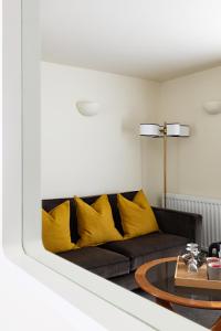 格拉斯米尔切斯特纳特别墅旅馆的客厅配有带黄色枕头的黑色沙发
