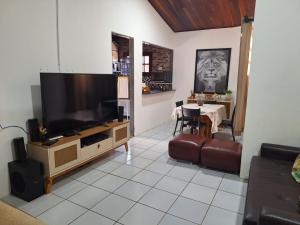 格拉瓦塔Casa de campo em Gravatá的客厅配有大电视和桌子