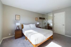 坎贝尔South San Jose 3br w garage wd backyard SFO-1506的卧室配有一张白色大床和两盏灯。
