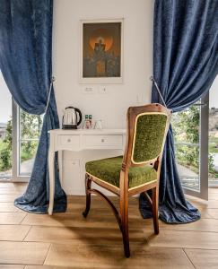 KojskoPeterc Vineyard Estate的一张桌子和一把椅子,位于带蓝色窗帘的房间