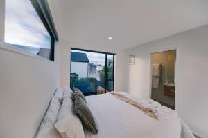 Charming Retreat in the Heart of Christchurch City-CBD的白色的卧室设有一张大床和一个窗户