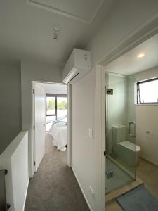 Charming Retreat in the Heart of Christchurch City-CBD的一间带玻璃淋浴间的浴室和一间卧室
