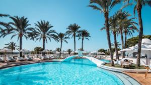 帕格拉Hilton Mallorca Galatzo的棕榈树度假村的游泳池